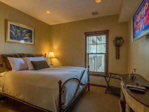 A bedroom with a bed, a lamp, a window, a TV, and a painting on the wall. - 3 Br: Soaring Eagle 301 (Snowshoe)