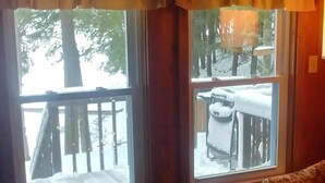 A room with two windows, a wooden floor, and a patterned rug. - Family friendly lakefront cottage (Pickerel)