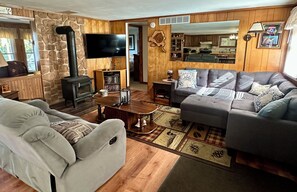 A cozy living room with a fireplace, a television, and a sofa. - Cozy Cottage (Pickerel)