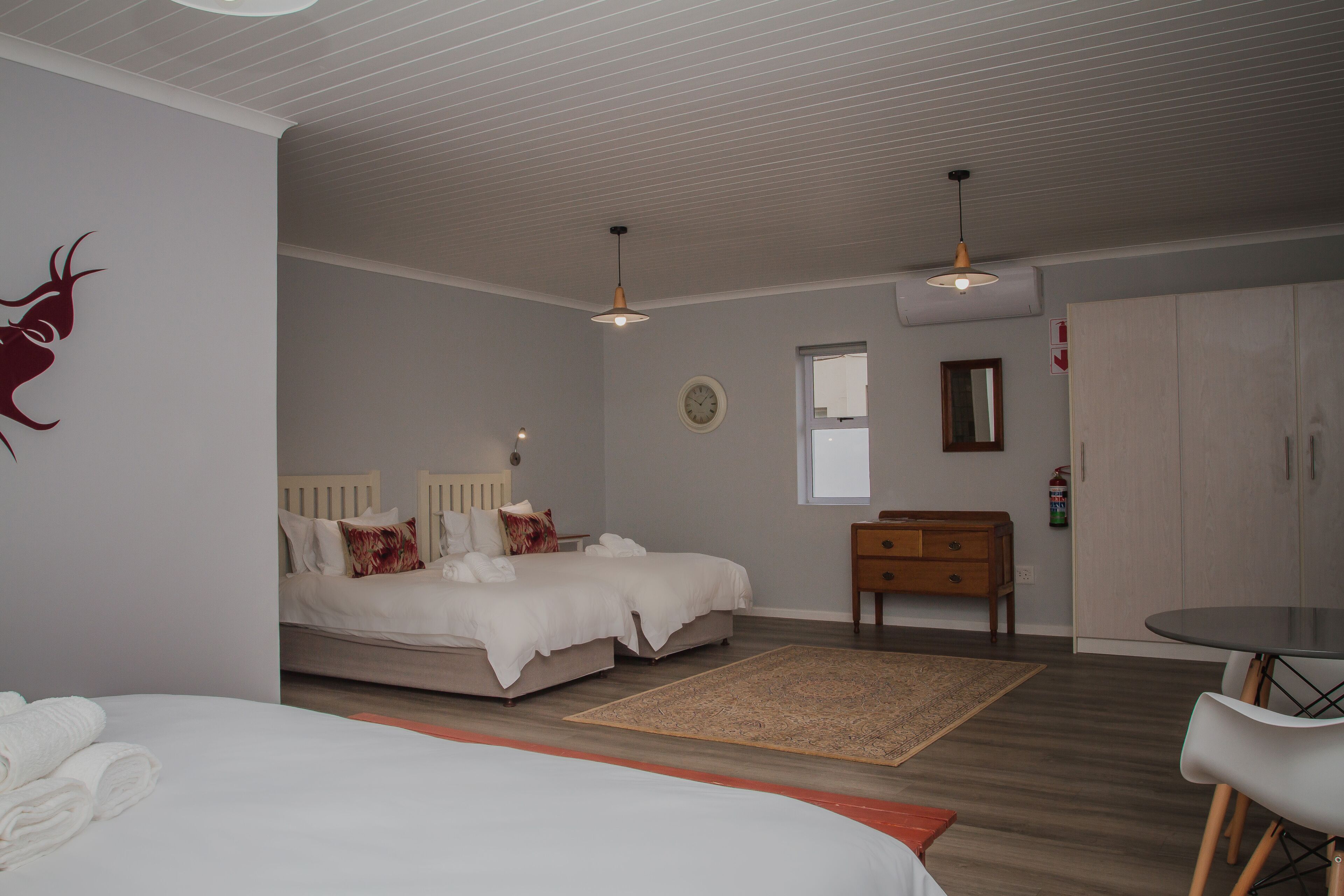 A bedroom with a bed, bedside tables, a dresser, a small table, and a chair.