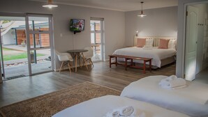 Une chambre d’hôtel moderne équipée d’un grand lit, d’un lit plus petit, d’un bureau et d’une télévision.