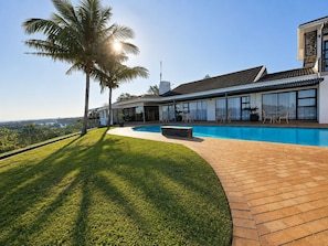 A modern house with a swimming pool, a covered patio, and a view of the landscape. - The Ridge Guesthouse (Richards Bay)