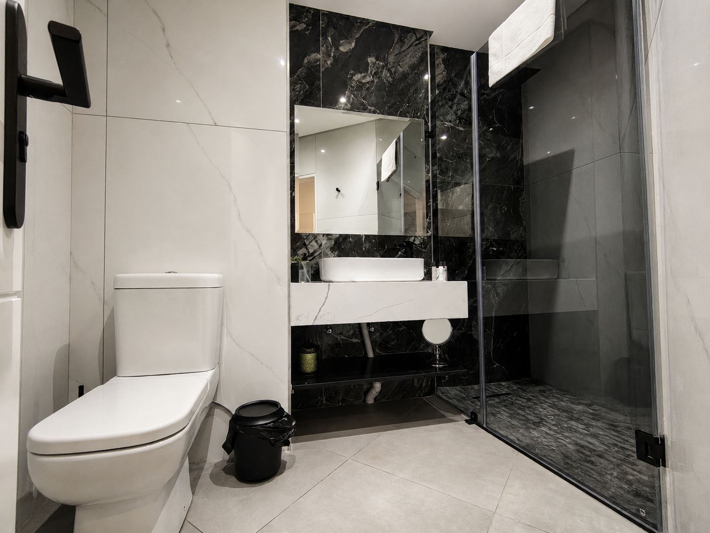A modern bathroom with a toilet, sink, and shower area.