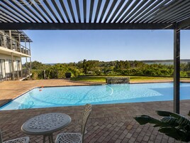A swimming pool with a view of a building and trees in the background.