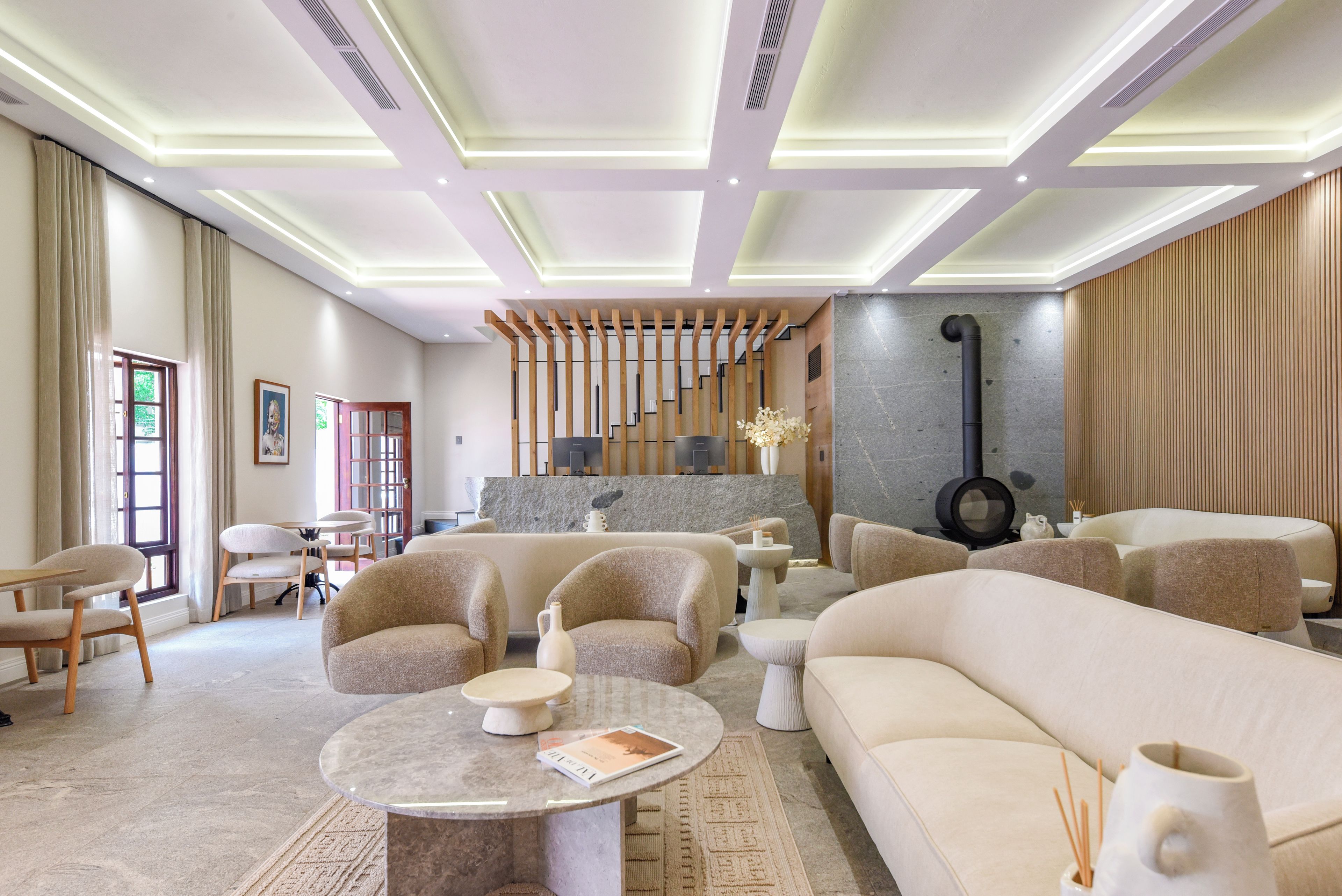 A modern living room with a fireplace, sofas, a coffee table, and a stone accent wall.