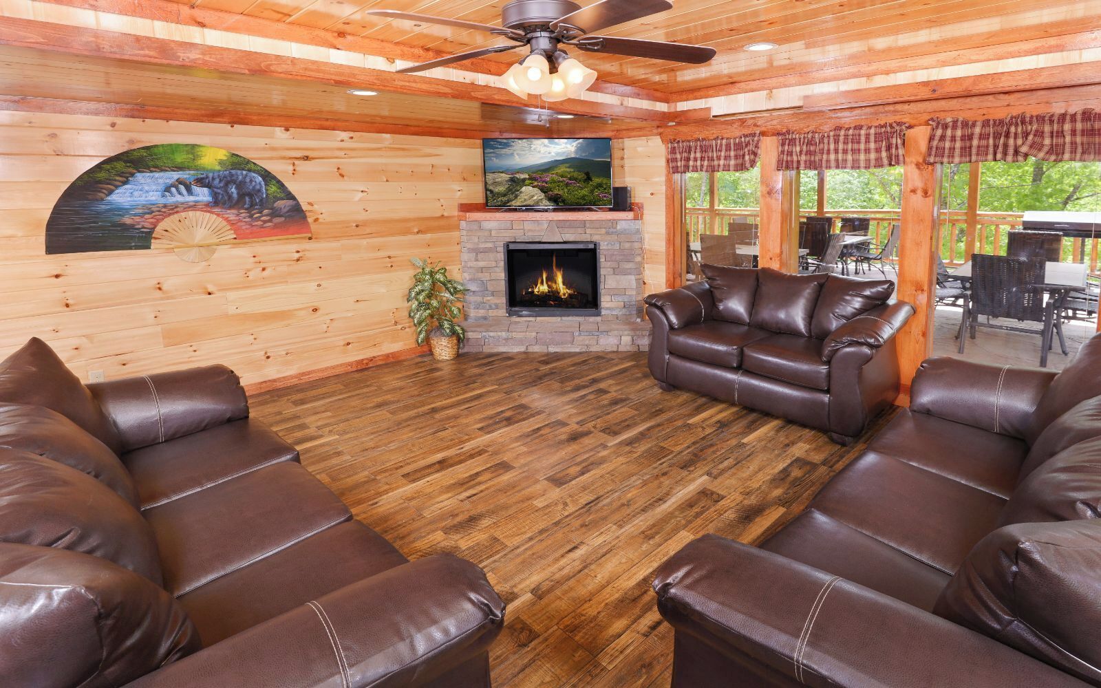 A cozy living room with a fireplace, leather sofas, and a wooden floor.