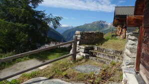 A rustic wooden cabin with a stone wall and a wooden fence leading to a mountain path. - Beautiful chalet in 3918 Lauchernalp, Wiler, Valais (Wiler (Lötschen))