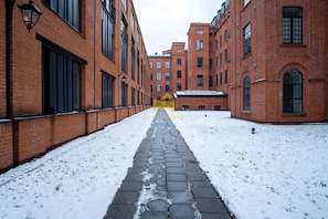 Walking paths lead through the historic property, lined by brick buildings with large windows.