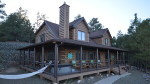 A log cabin with a porch, multiple windows, and a chimney. - Lone Pine Lodge - Prescott Cabin Rentals (Prescott)