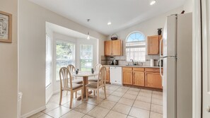 Enjoy meals with a view at this kitchen and dining area, featuring a dining table for four and a well-equipped kitchen with oven and refrigerator.