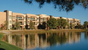 Un hotel modern amb diverses edificacions, un llac i vegetació als voltants.