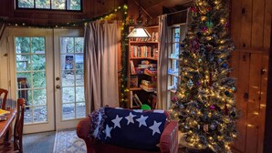 A cozy cabin interior with a Christmas tree, a bookshelf, and a dining area. - Dandelion's Lair, a 3 bedroom, 2.5 bathroom cabin in Twain Harte! (Twain Harte)