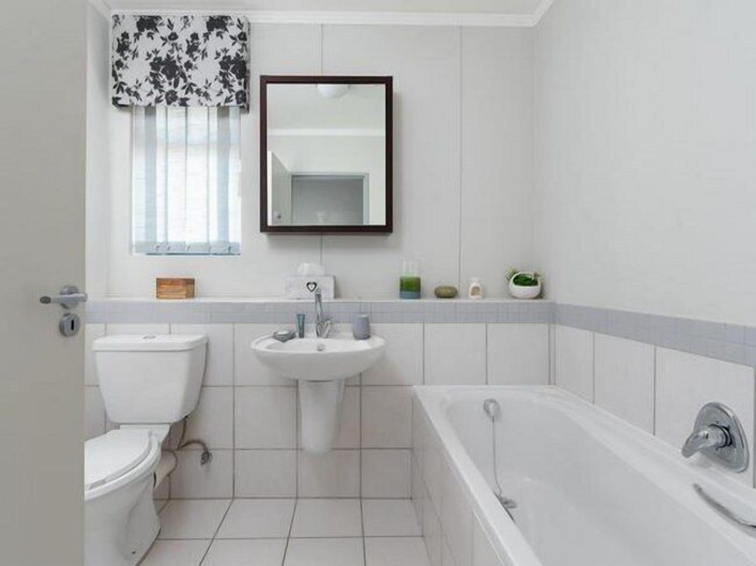Een badkamer met toilet, wastafel en bad.