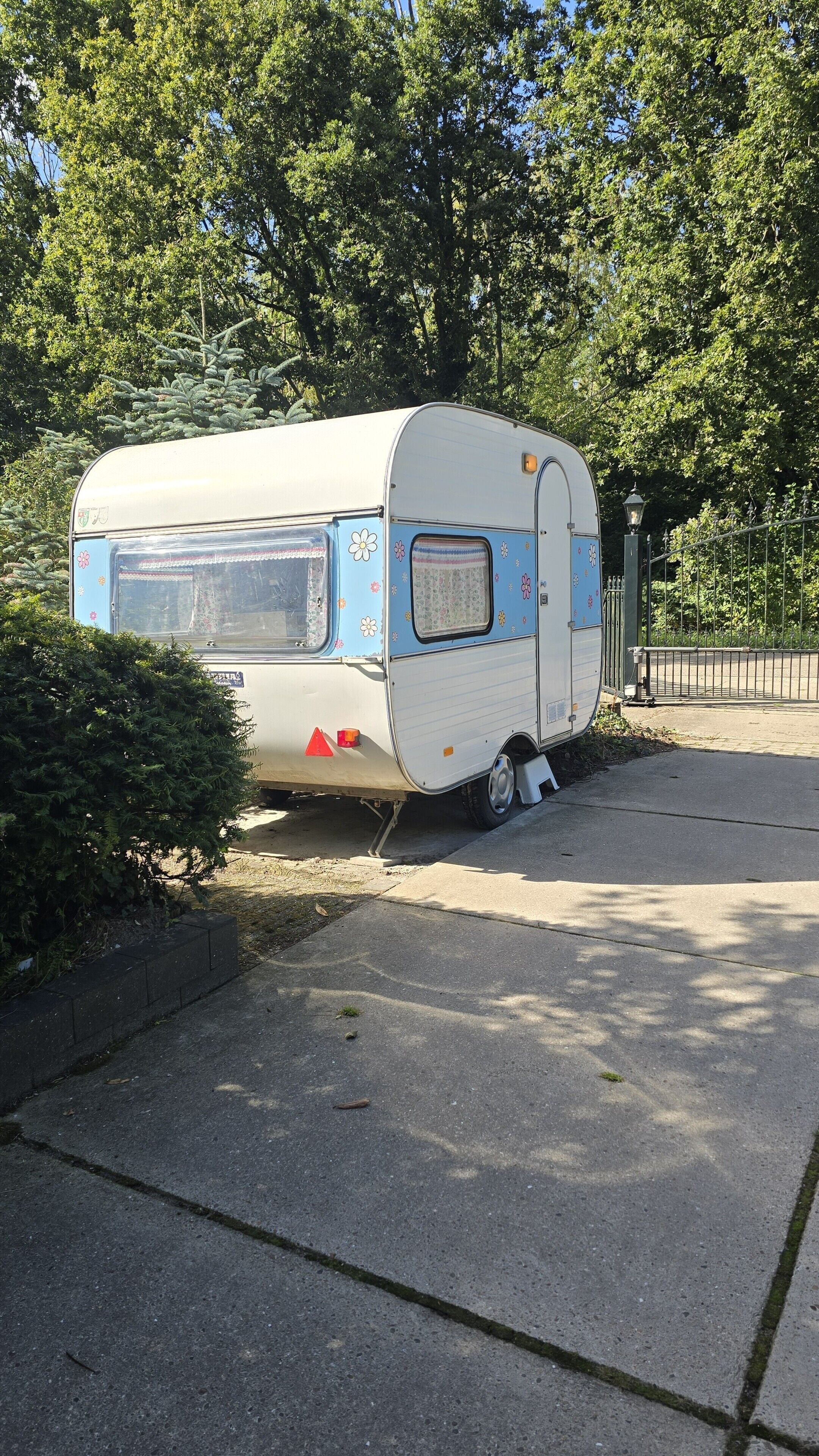 A stationary recreational vehicle parked on a sidewalk.