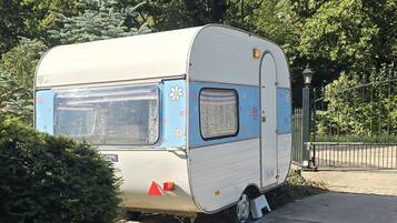 A stationary recreational vehicle parked on a sidewalk.
