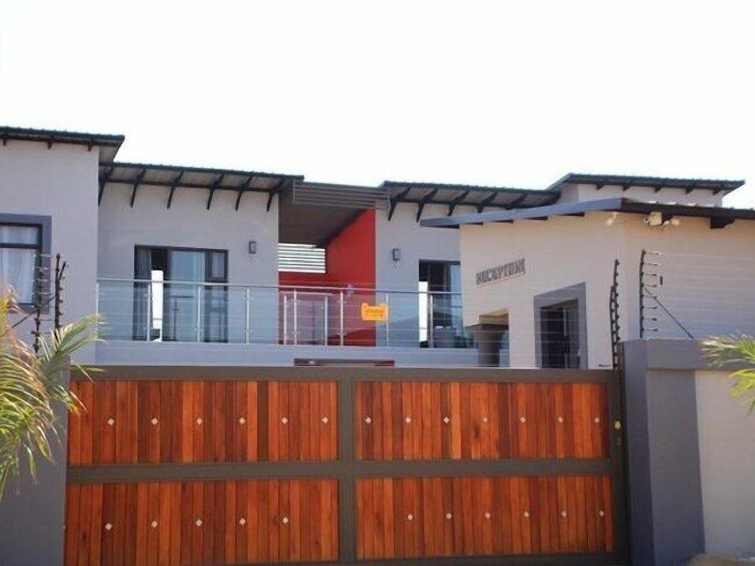 A modern building with a reception area, a wooden fence, and a balcony.
