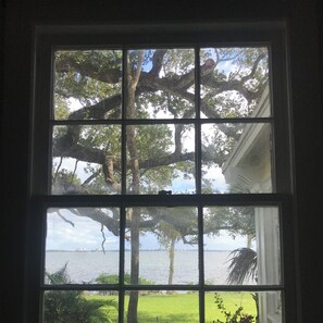 Enjoy serene views of a tranquil lake or river from this room's four-paned window.