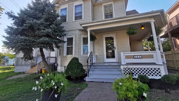 A two-story house with a front porch, a mailbox, and a number 468 sign.