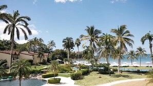 A resort with multiple pools, palm trees, and a beach view.