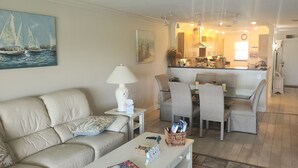 Una sala de estar con sofá, una mesa de centro y un comedor con sillas y una mesa.