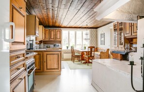 Kitchen features a central island with seating, oven, and microwave, complemented by a dining area with a table and chairs.