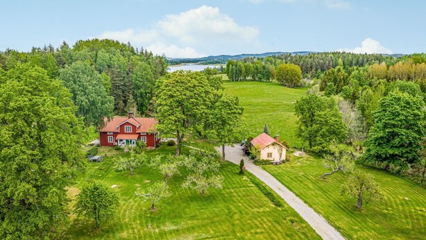 A large house with a red roof surrounded by lush green fields and trees. - Awesome home in Långserud with WiFi (Långserud)