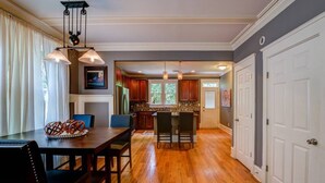 A spacious kitchen with wooden cabinets, a central island, and pendant lighting. - 3 BR Charleston Style Home- 3 levels with garage (Atlanta)