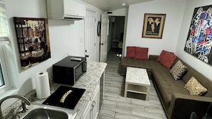 Un espacio habitable compacto con cocina, mesa de comedor y sofá.