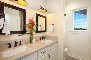A bathroom with two sinks, a large mirror, and a window with a view. - Hale Lo'i Cottage: Luxury + Convenience in Poipu (Koloa)
