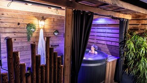 Un espace de détente en bois comprenant un jacuzzi, des murs en bois et un rideau.