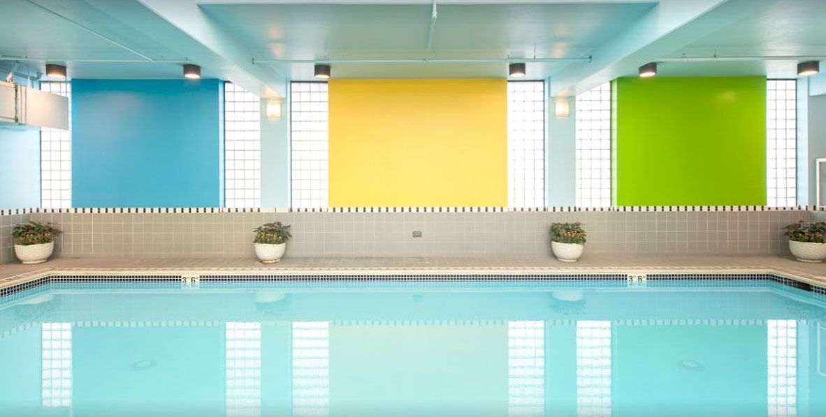 Una piscina con paredes de azulejos en tonos azul, amarillo y verde.