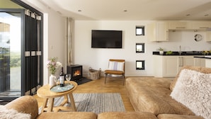 Un salon moderne avec un canapé, une table basse en bois, une cheminée et un téléviseur fixé au mur.
