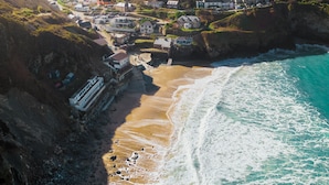 Une ville côtière avec des maisons construites le long de la falaise, une plage et un port de plaisance.