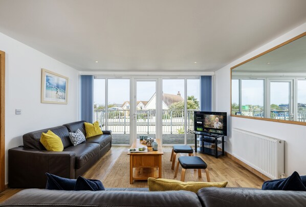A modern living room with a sofa, a coffee table, and a TV.