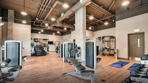 A gym with cardio machines, weightlifting equipment, and exercise mats. - Bell Overlake (Redmond)