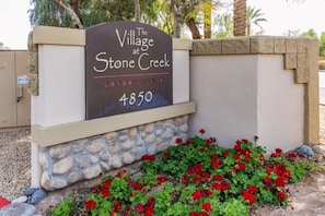 Welcome to The Village at Stone Creek, where a charming garden surrounds the entrance.