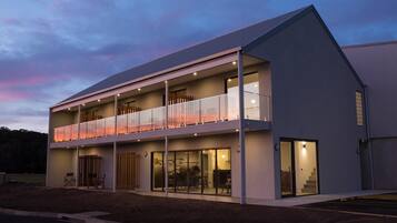 Vista frontal de la propiedad por la tarde o noche