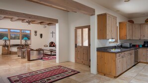 Une cuisine spacieuse avec des meubles en bois, un four encastré et une grande fenêtre.