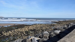 Een rotsachtige kustlijn met golven die op het strand breken.
