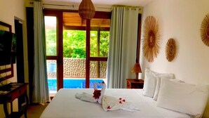 Une chambre d’hôtel équipée d’un lit, d’une télévision, d’un bureau et offrant une vue sur une piscine.
