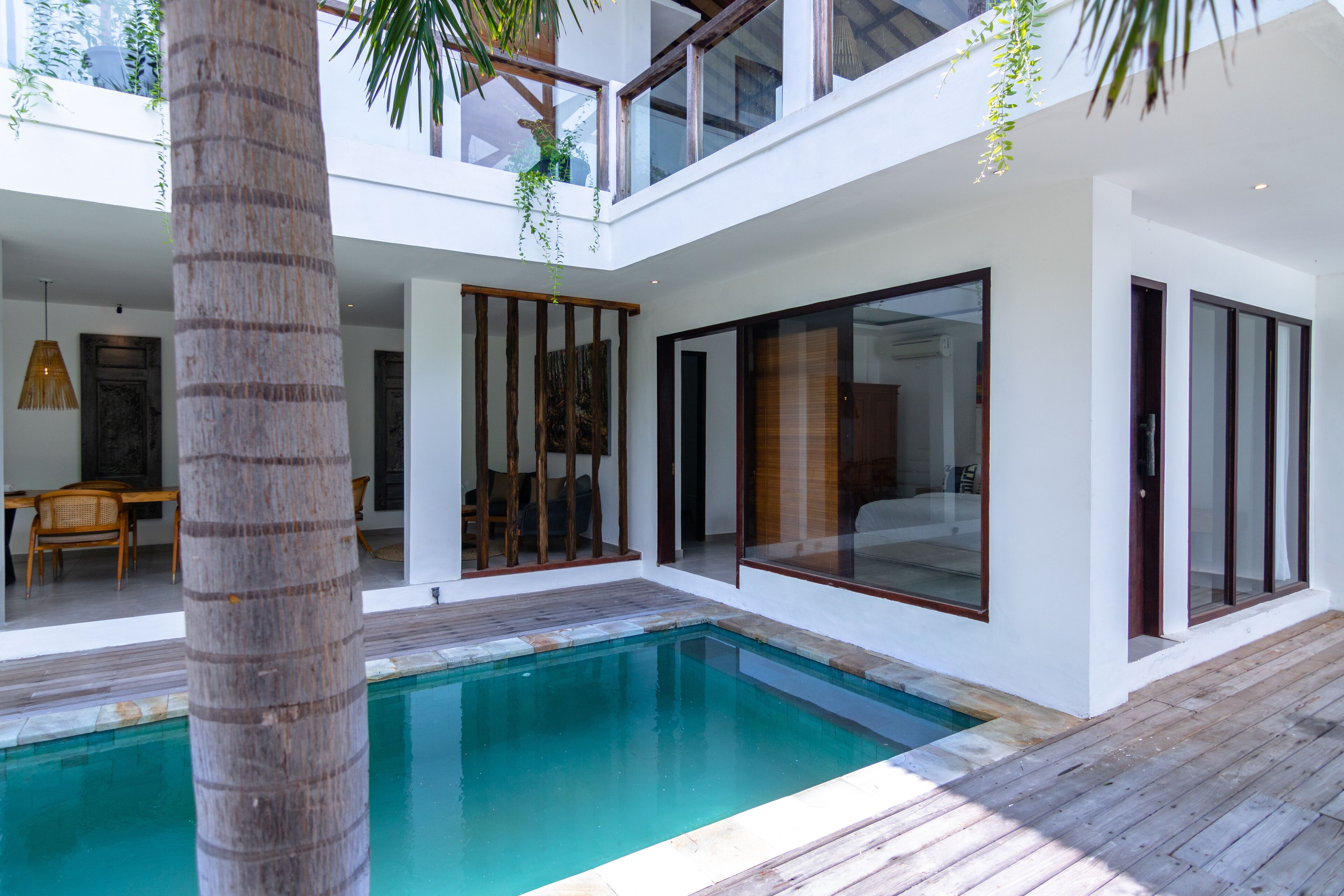 A modern house with a pool, wooden deck, and large glass doors.