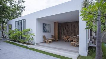 A modern house with a patio, outdoor furniture, and a garden.