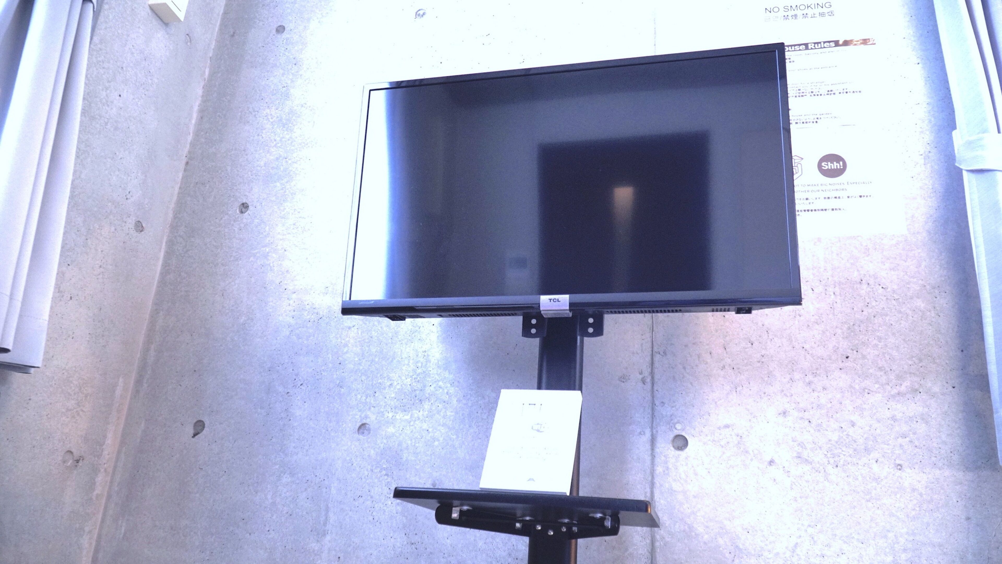 A flat-screen TV mounted on a wall with a metal bracket.