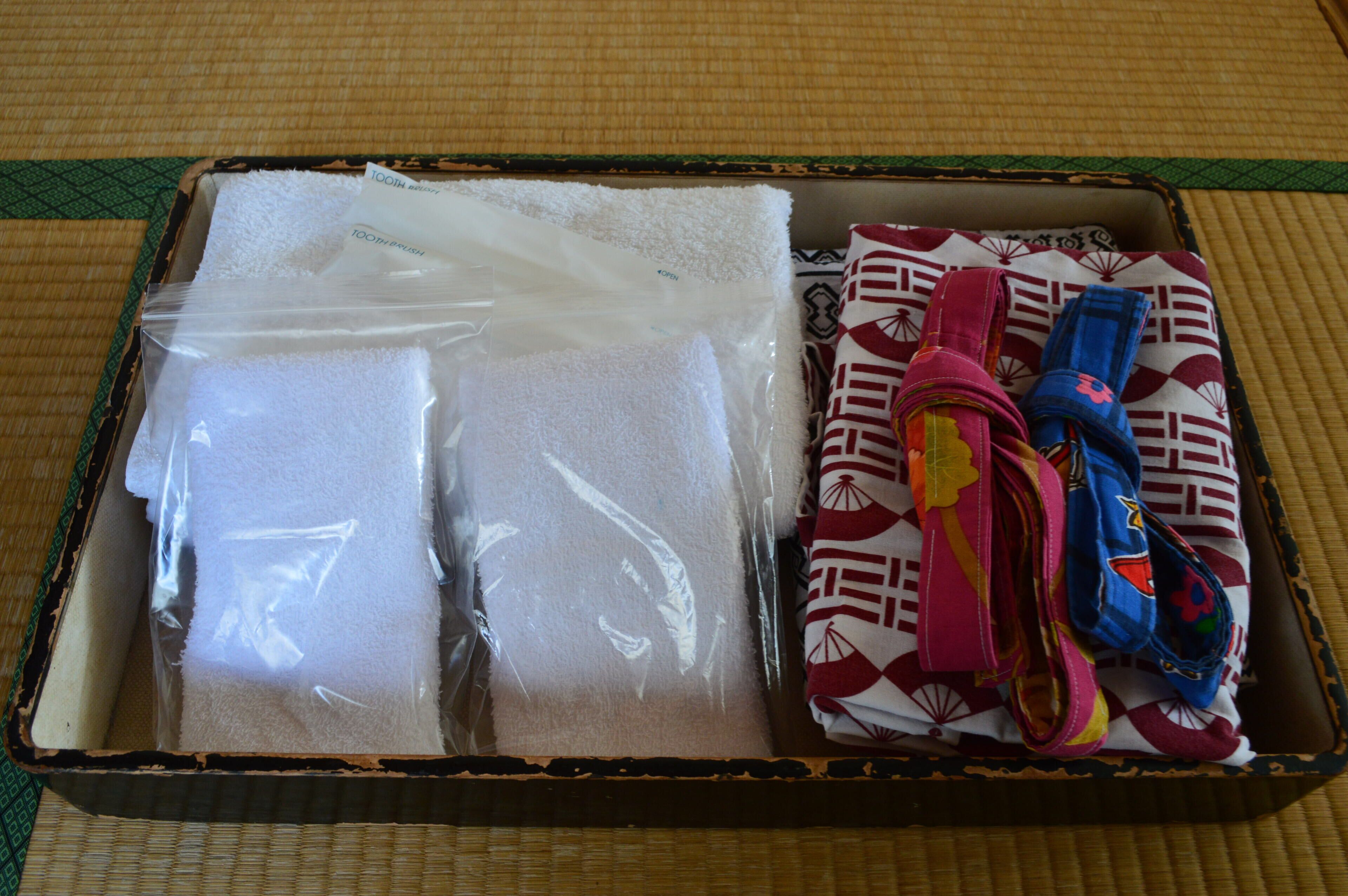 A suitcase with a white towel and a patterned cloth inside.