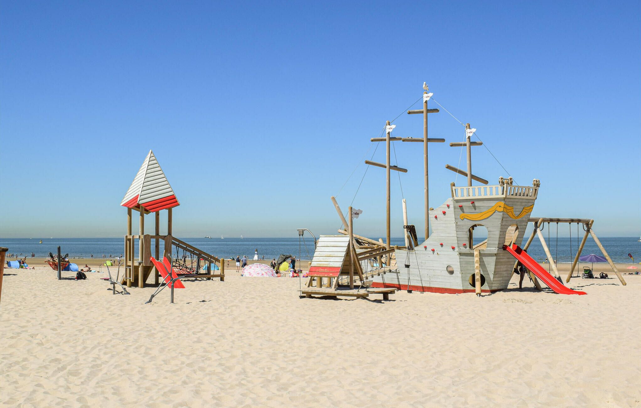 A beach with a lifeguard tower and a wooden play structure.