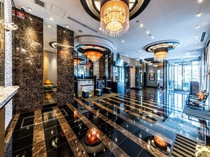 A modern lobby with a marble floor, a reception desk, and a chandelier. - APA Hotel Chiba Ekimae (Chiba)