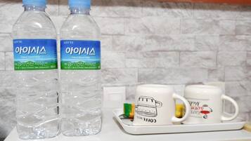 Deux bouteilles d’eau et deux tasses à café sur un plateau.