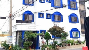 A white building with blue window frames and a sign in a foreign language. - Healinghouse Peakjang (Buyeo)