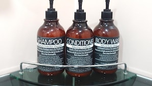Three bottles of hair care products on a glass shelf. - Healinghouse Peakjang (Buyeo)