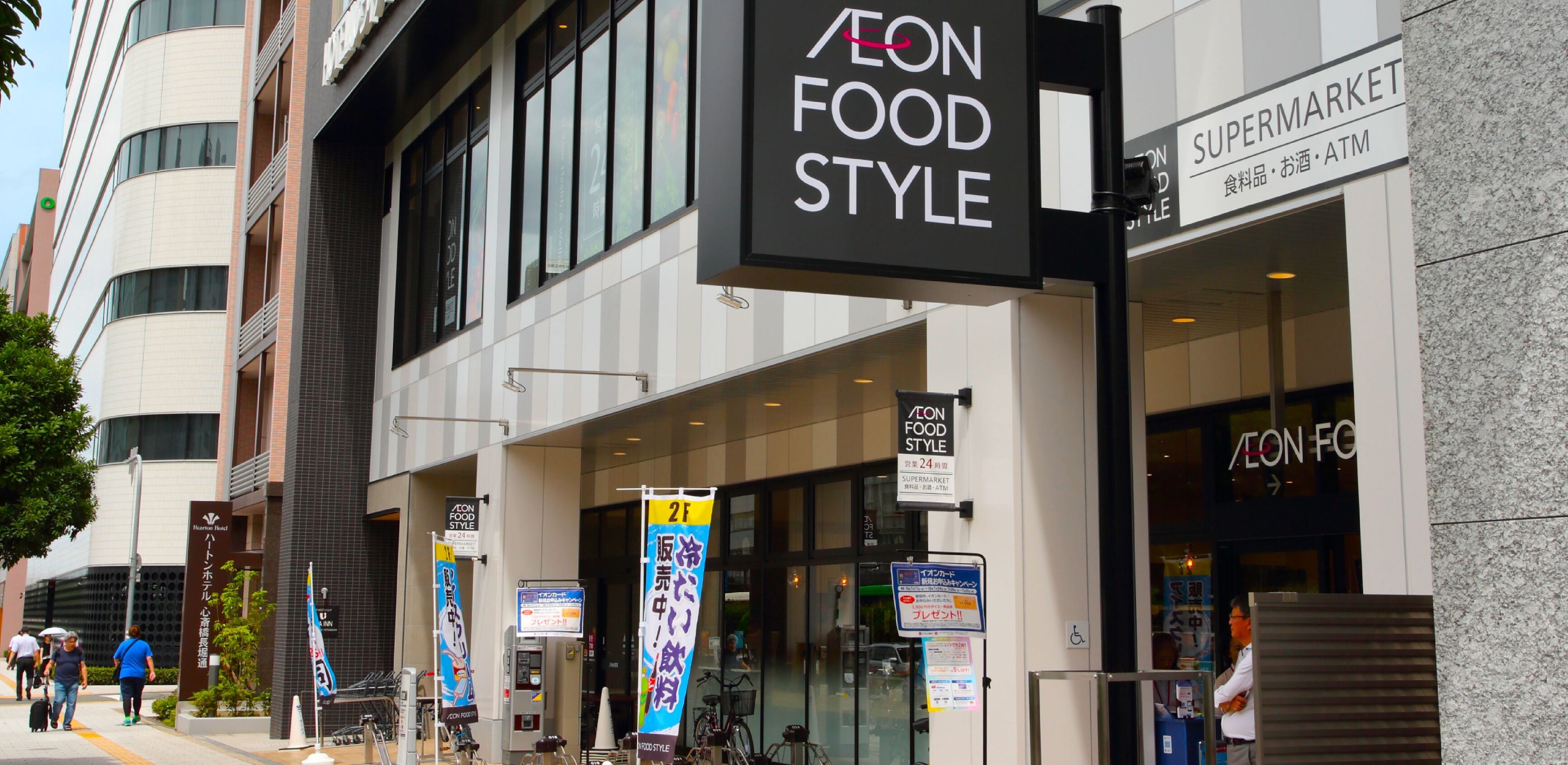 A building with a 'AEON FOOD STYLE' sign and a 'SUPERMARKET' sign.